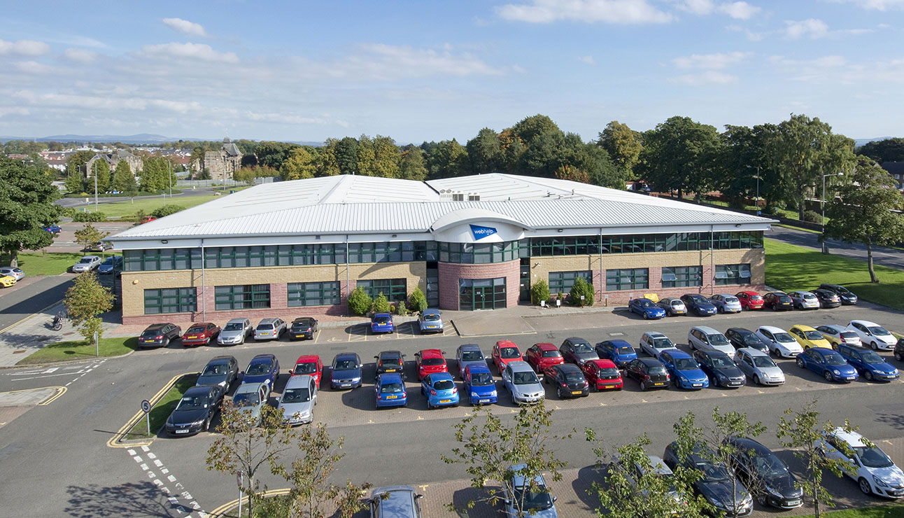 Elevated view of a commercial building with busy car parking area