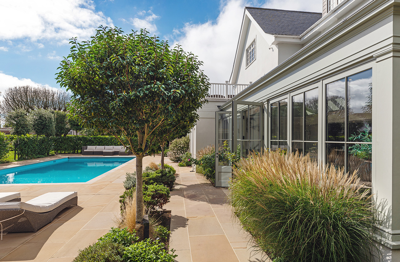 Residential property with orengery taken in summer overlooking a pool