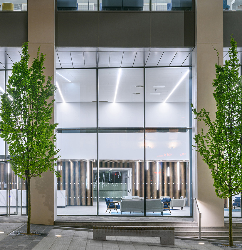 Commercial office detail looking through glazing into reception area at dusk