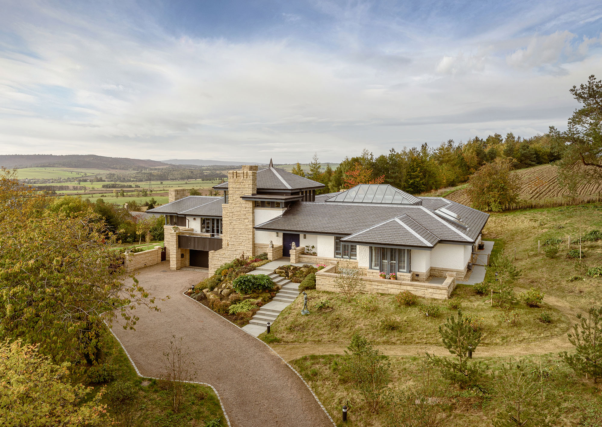 Elevated exterior or a residential property with landscaping in the forground and views over the countryside