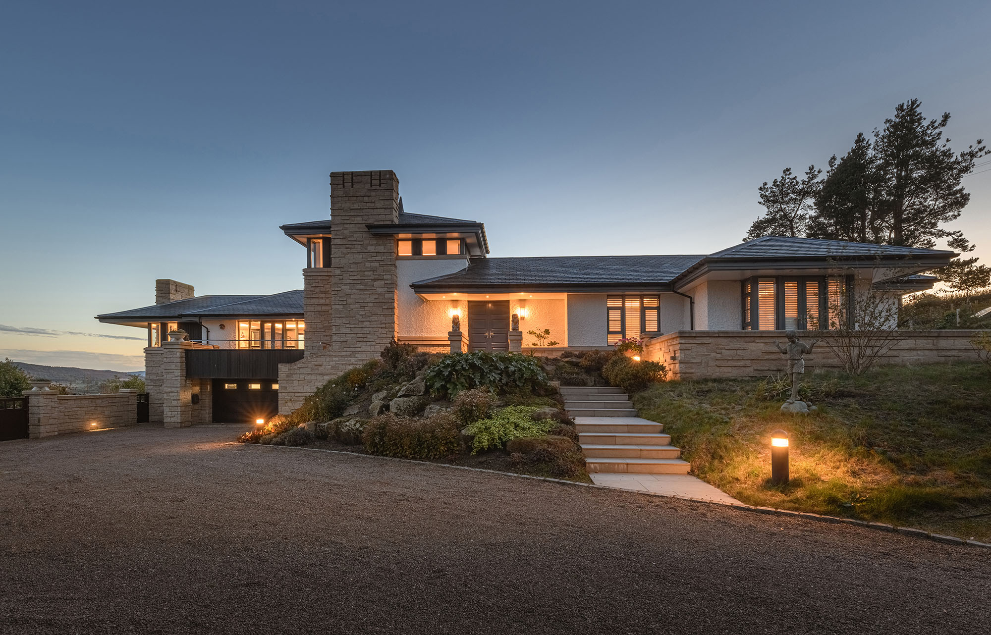 Dusk exterior of a property with steps and driveway with rockery