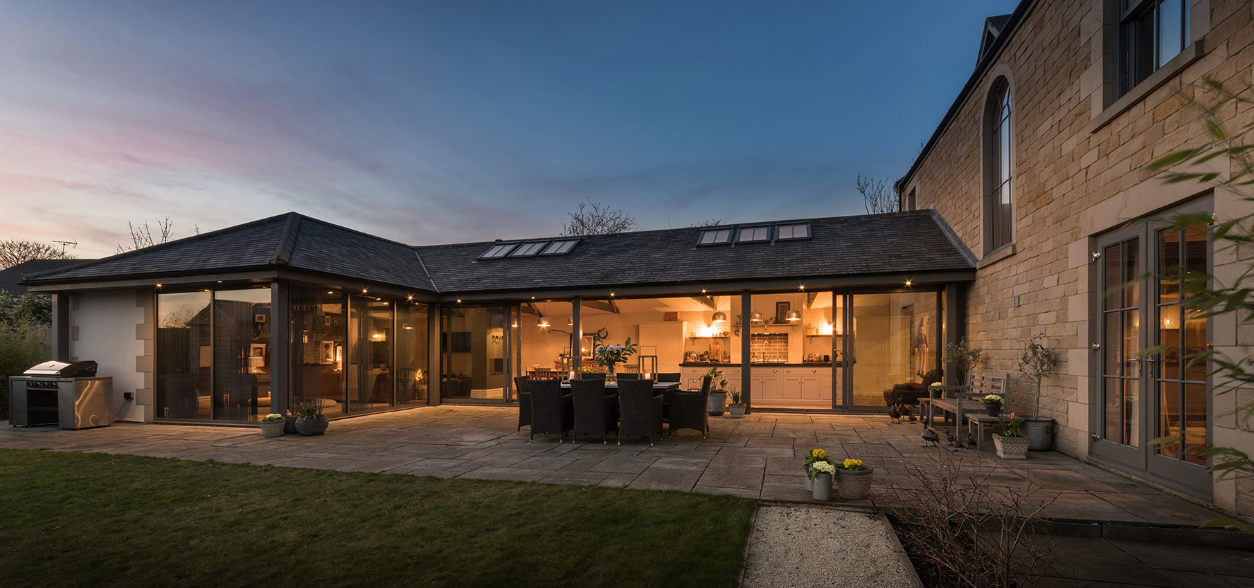 Residential property at dusk with views into open plan kitchen