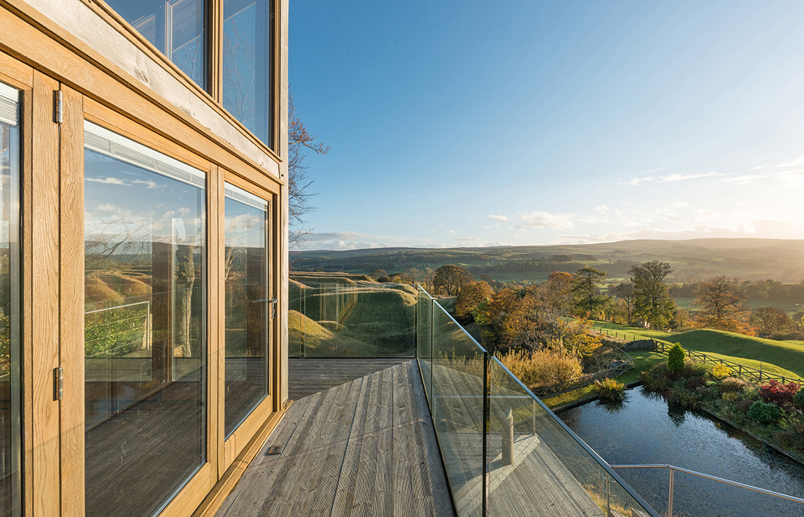 Exterior of a residential property with large glass windows overlooking the countryside