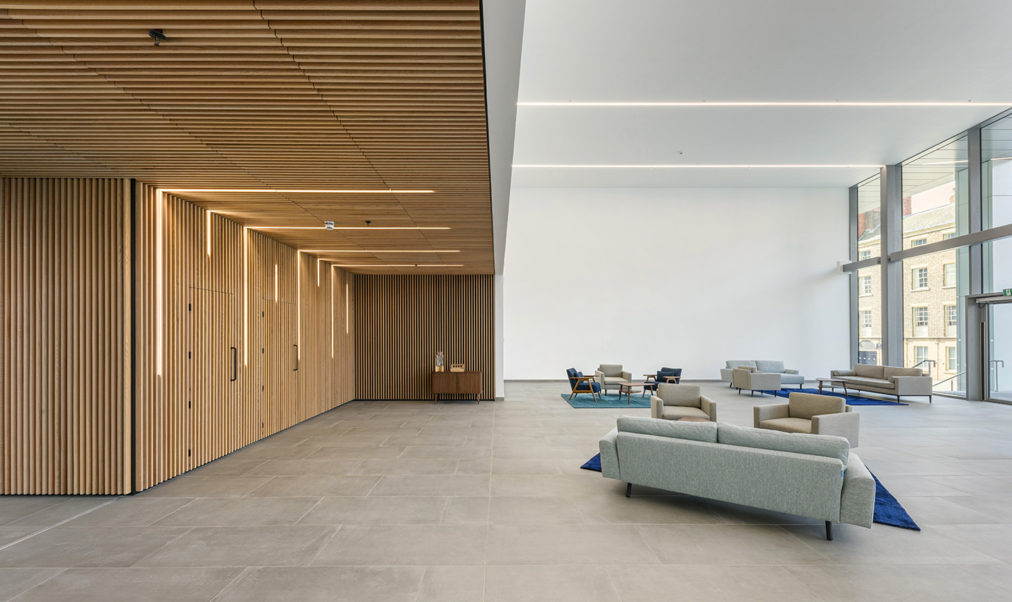 Interior of a commercial office building reception area with large windows and a wooden wall and ceiling