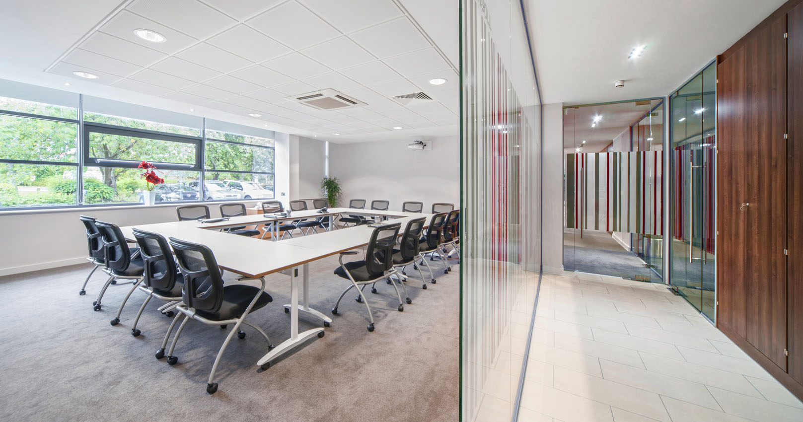 Office and workplace interior with glass partition wall and office furniture