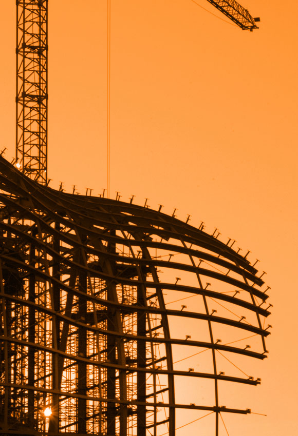 sunset showing a construction site with crane and steel framework