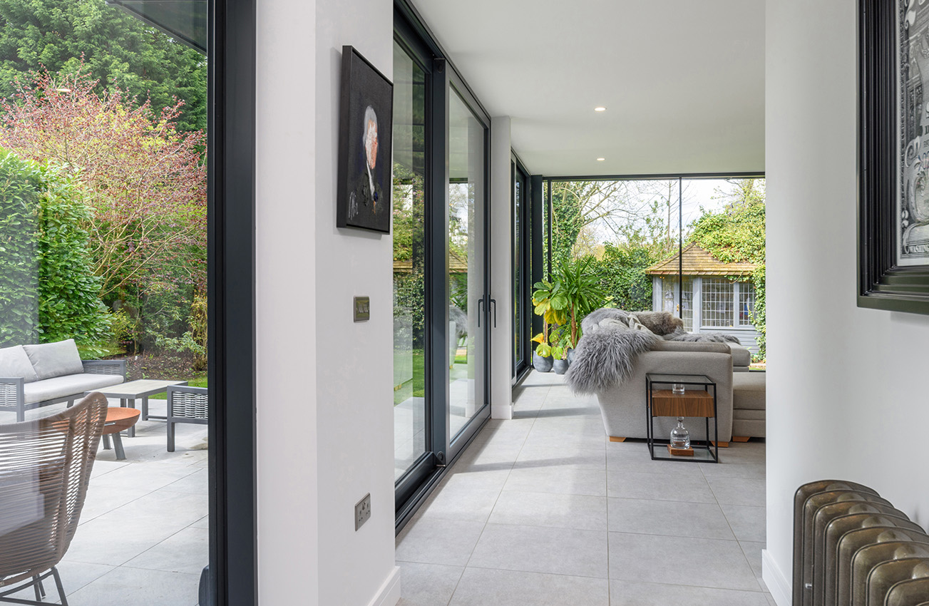 Interior of a garden room looking down a glazed wall with a view into the garden area