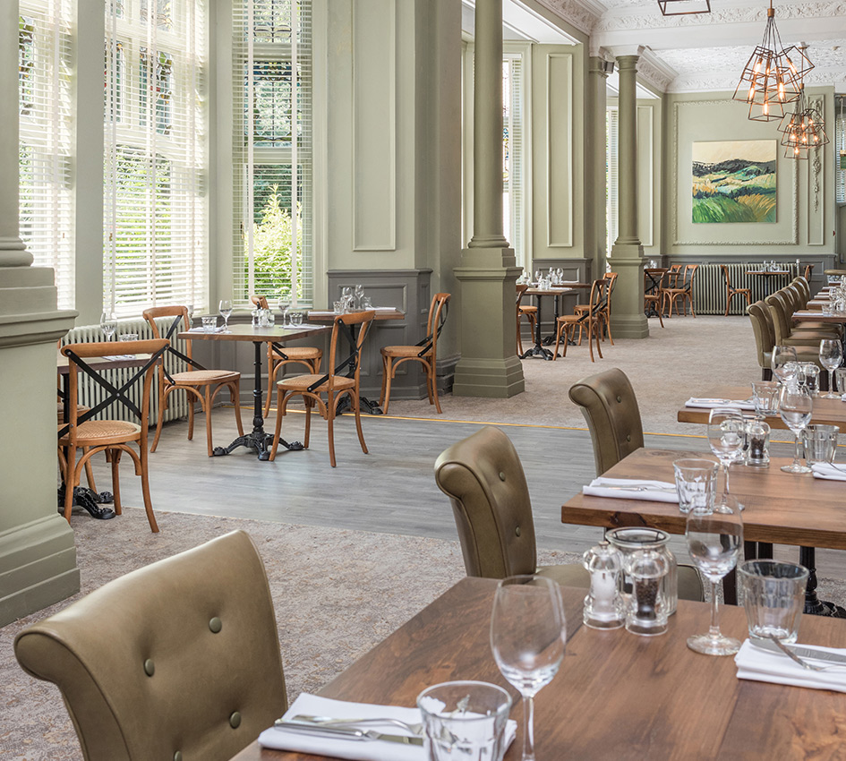 Interior of a hotel dining area looking past tables to wider room