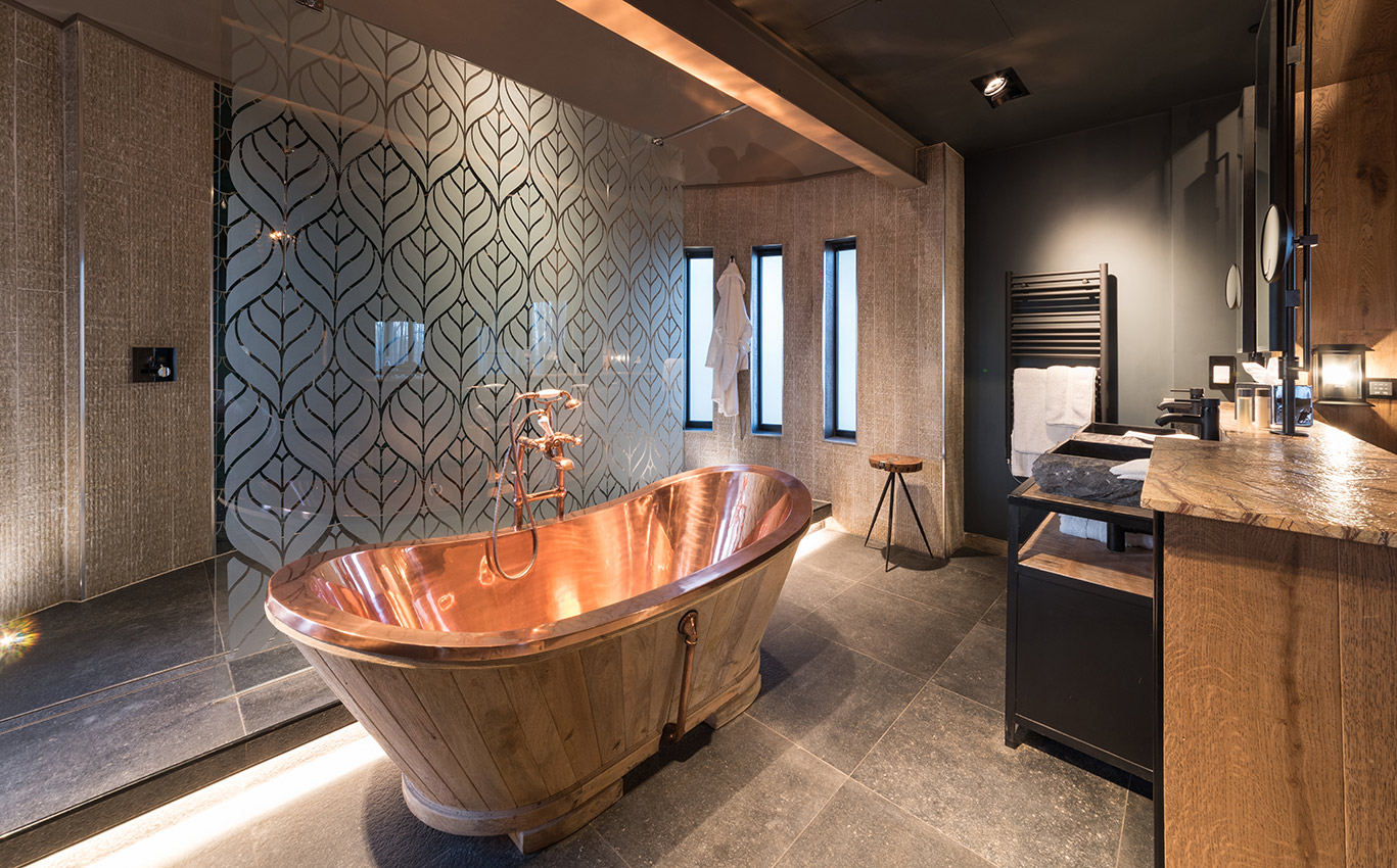Hotel bathroom with copper roll top bath and large walk in shower area