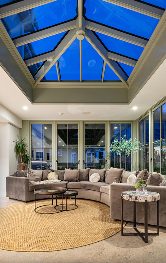 Orengery detail at dusk with large lantern window and modern furniture