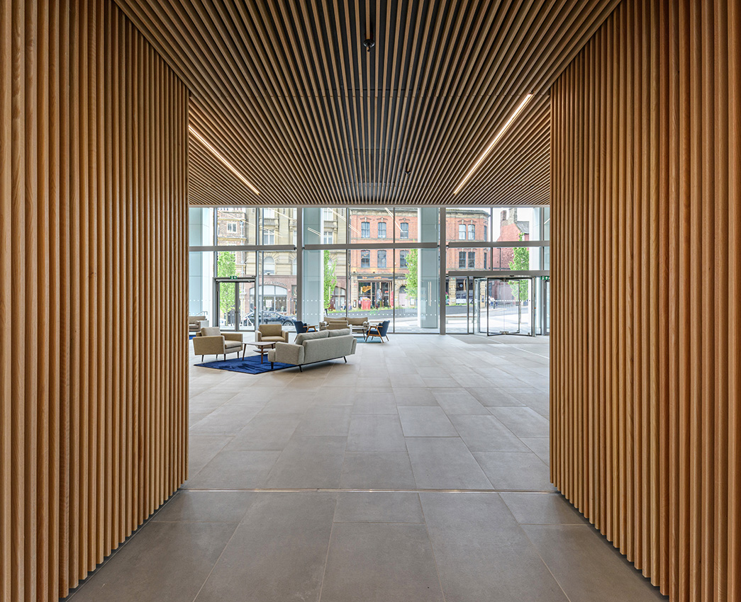 Interior of a commercial office building with wooden design features looking towards a glazed area