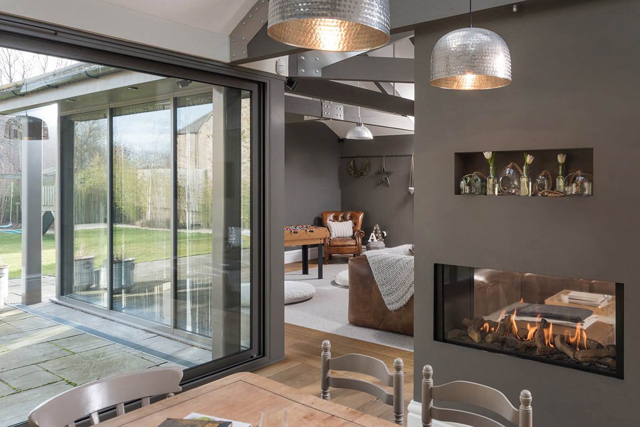 Interior of an open plan kitchen looking through a glazed area to the garden