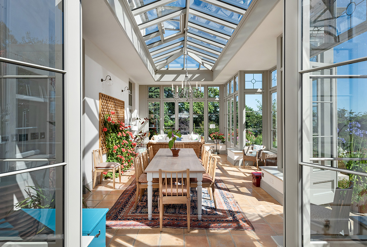 Orangery interior detail looking through doors to dining area in sunshine