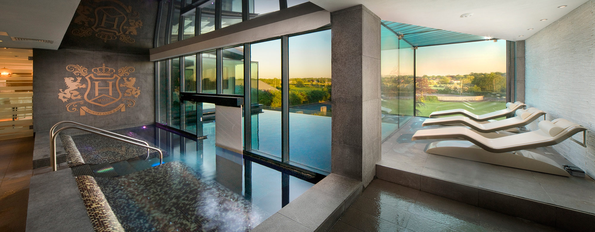 Interior of a leisure facility with rooftop pool and views through large glass windows