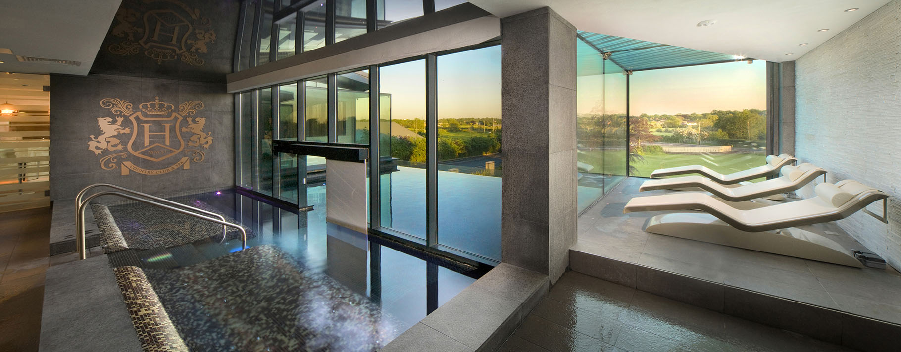 Interior of a country club leisure area with pool and glazed wall overlooking the countryside