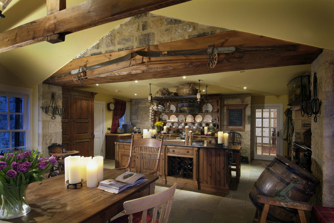 Wooden kitchen with exposed wood beams at dusk with candles and warm lighting