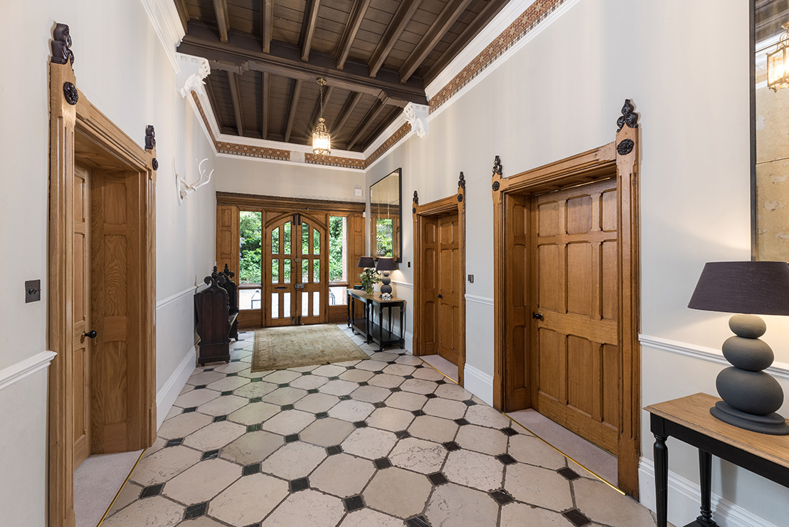 Period propert interior of a hallway with tiled floor and wooden doors
